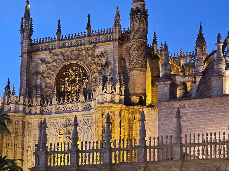 Cattedrale di Siviglia illuminata di notte con dettagli gotici e decorazioni in pietra