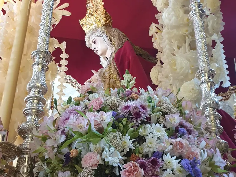 Virgen della Semana Santa su un paso decorato con fiori, candele e candelabri d'argento