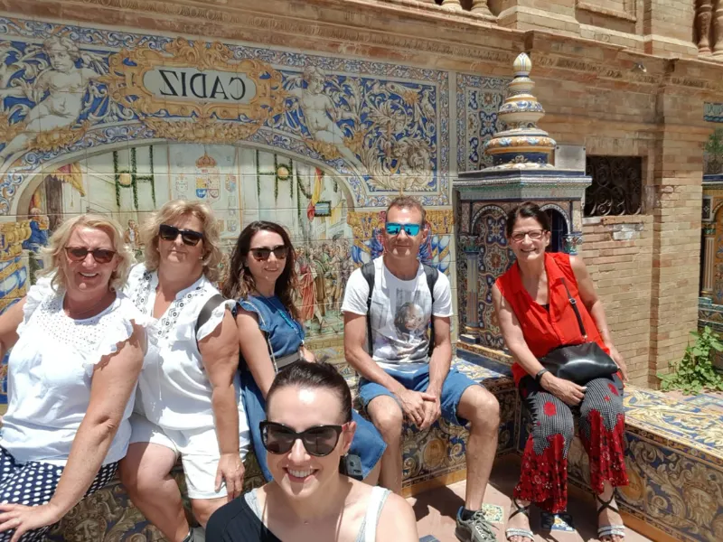 Gruppo di visitatori davanti alle ceramiche di Plaza de España a Siviglia